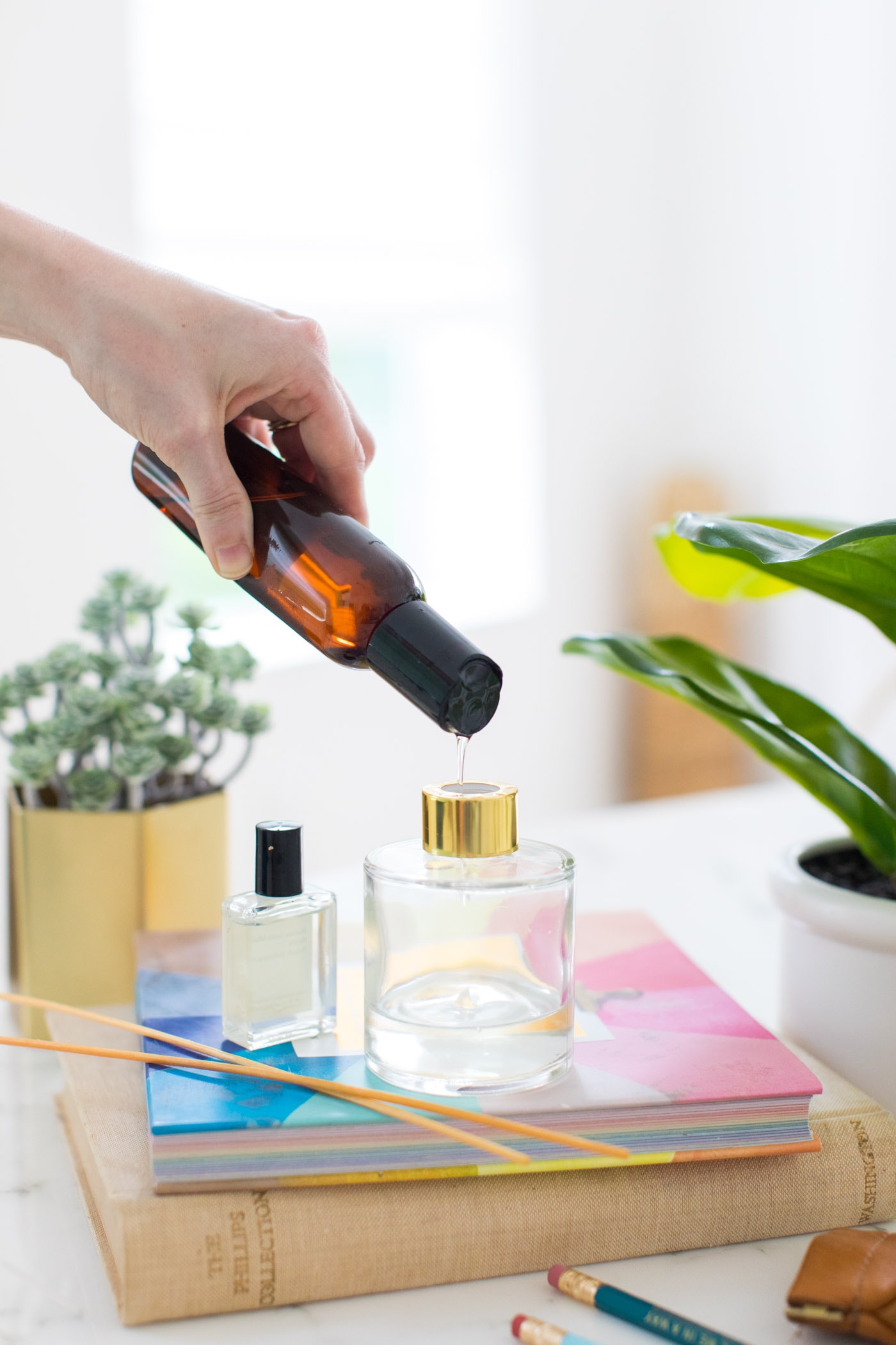 reed diffuser - photo of pouring essential oils into a diffuser bottle