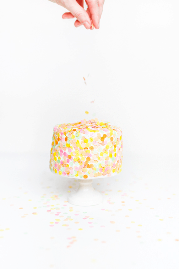 adding edible confetti toppings over a cake - edible confetti