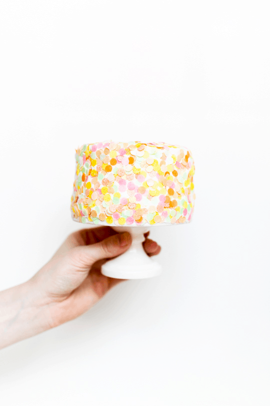 party city confetti poppers - holding the cake covered with edible confetti