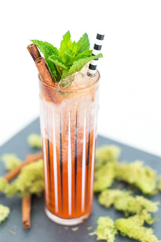 a zombie cocktail glass with cocktail and cinnamon sprig