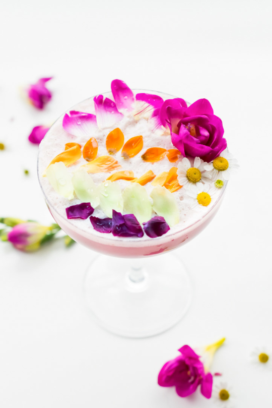 flowers for drinks - side view of the cocktail with petals on the table