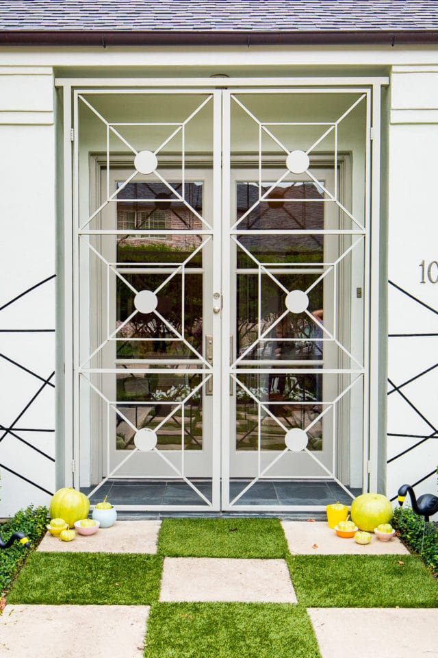 mid century metal doors and a checkered entrance! - Palm Springs Inspired Halloween Entryway Decor & Product Round Up by top Houston lifestyle blogger Ashley Rose - #halloweendecor #halloween #decor #home #holidays #curbappeal #palmsprings #midcentury