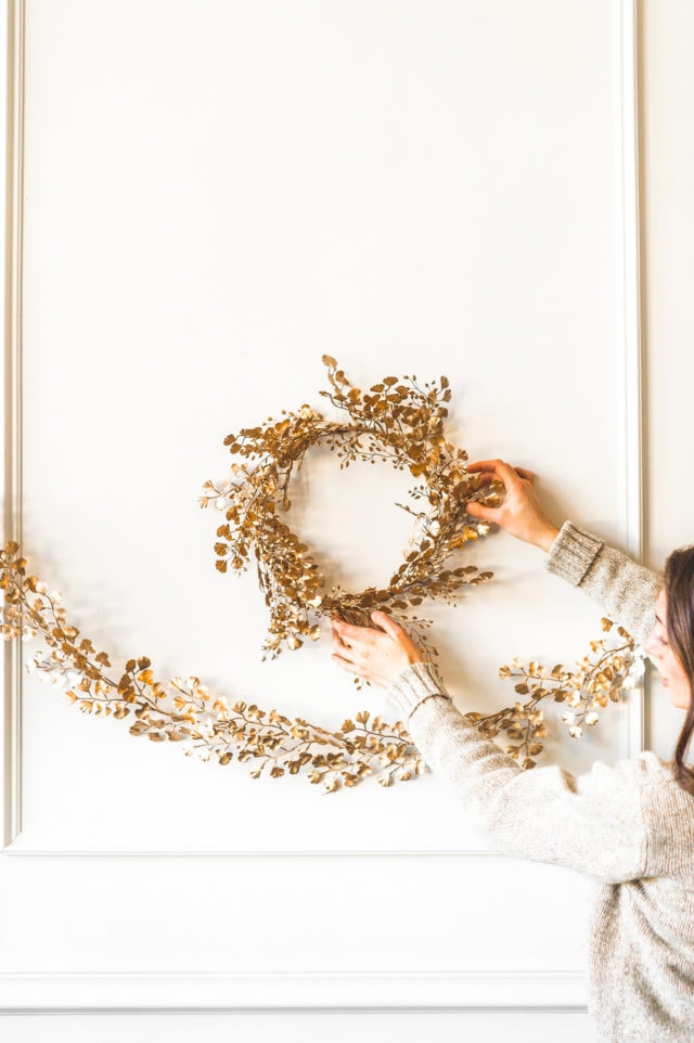 photo of the DIY Gold Wreath and DIY Gold Garland being hung up o the wall