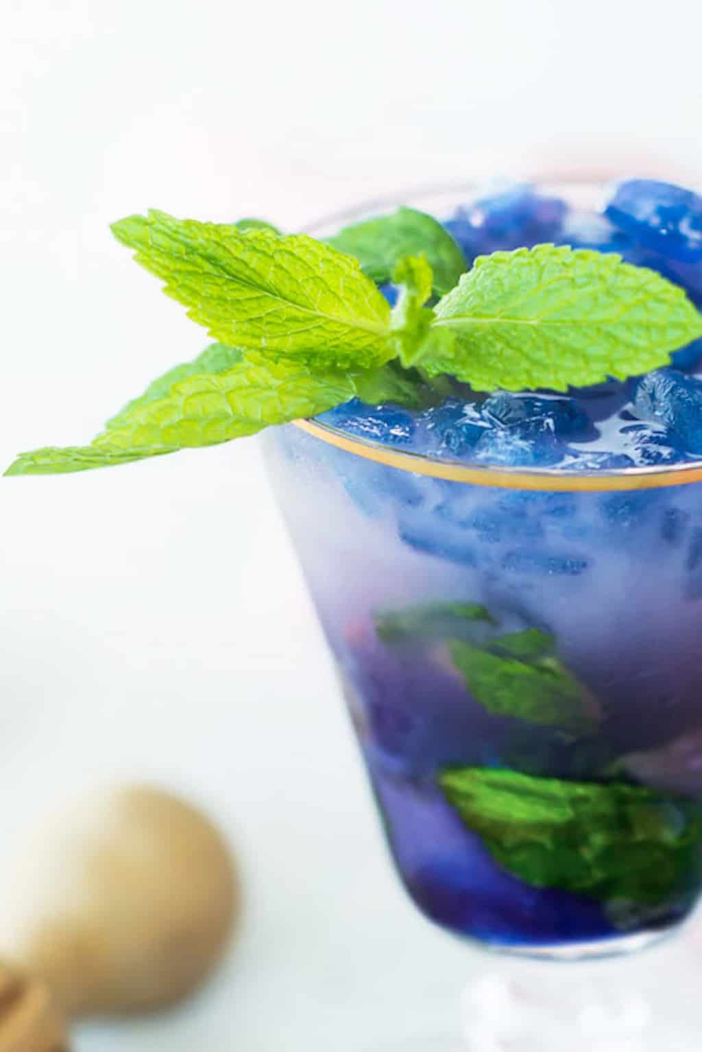 photo of a close up of the magic color changing Butterfly Pea Flower Tea Cocktail recipe by top Houston lifestyle blogger Ashley Rose of Sugar & Cloth