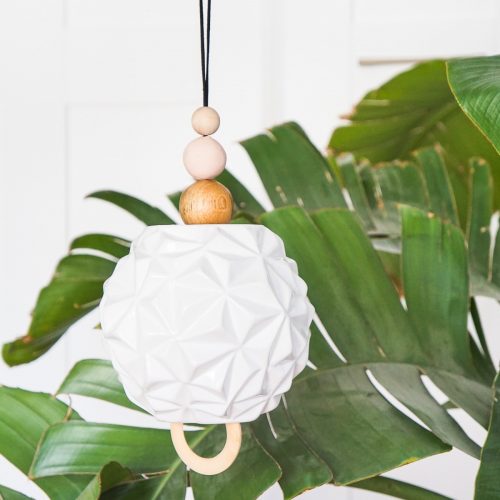 palm leaf with a white vase wind chime in front
