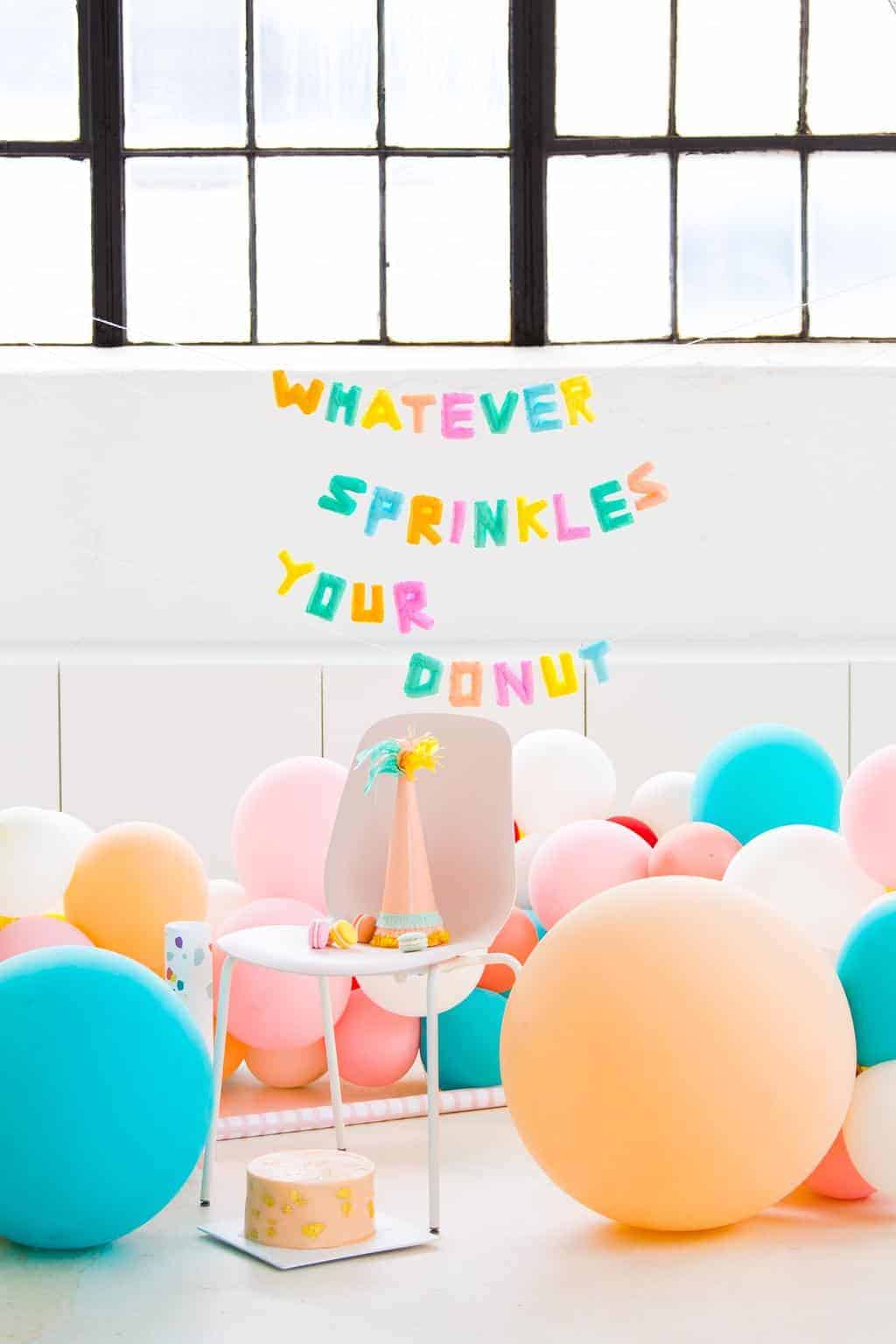 photo of a sprinkles and donut balloon garland decoration idea by sugar and cloth