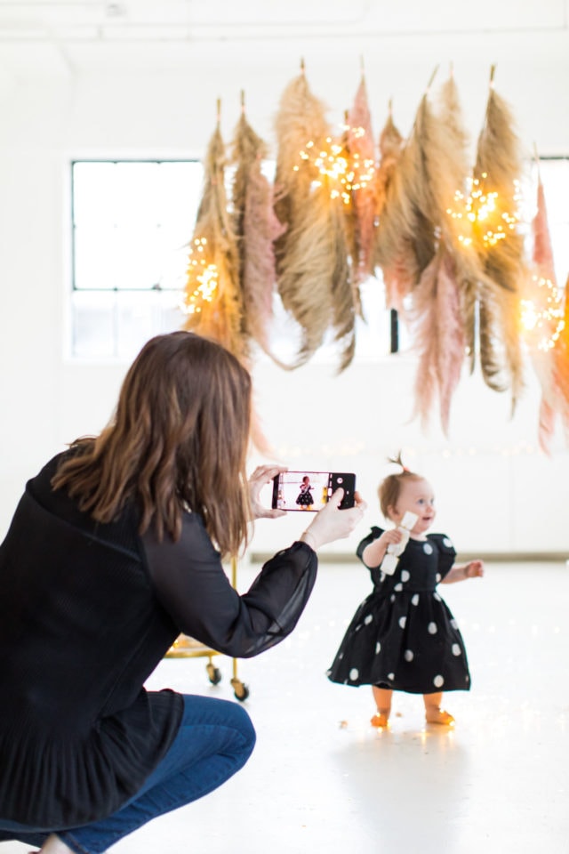 Snapping photos of the photobooth - Sharing photos via Live Albums and google hub! Pampas Grass DIY Photo Backdrop by top Houston lifestyle blogger Ashley Rose of Sugar & Cloth #diy #nye #backdrop #photography #photos #google #holidays #howto #weddings #parties #entertaining 