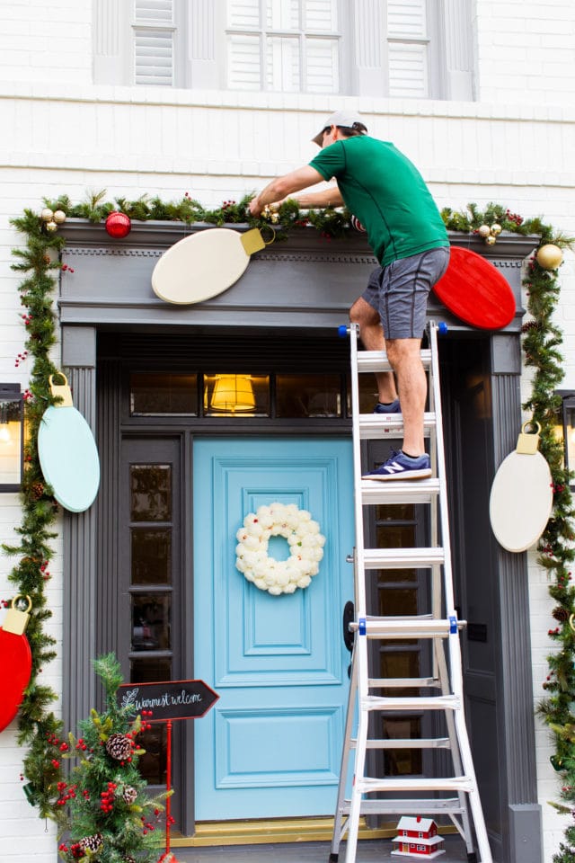 installing the decor! Jumbo Lights Outdoor DIY Christmas Decorations! by top Houston lifestyle blogger Ashley Rose of Sugar & Cloth #DIY #howto #christmas #holidays #decorations #decor #home #frontdoor #entrance