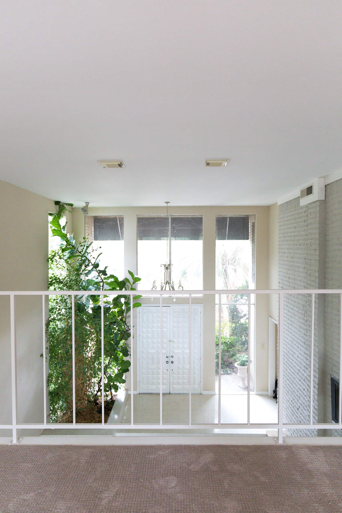 the view into the living room from the balcony upstairs - One Room Challenge Week 1: The Before Photos of Our Living Room + Dining Room by top Houston lifestyle blogger Ashley Rose of Sugar and Cloth #decor #homedecor #diy #interiors #renovations