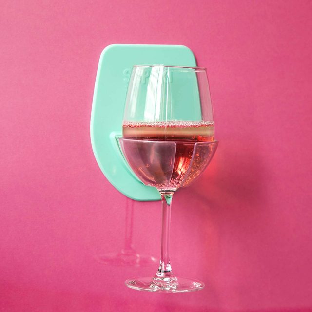 photo of a glass of wine hanging in a suction wine glass holder