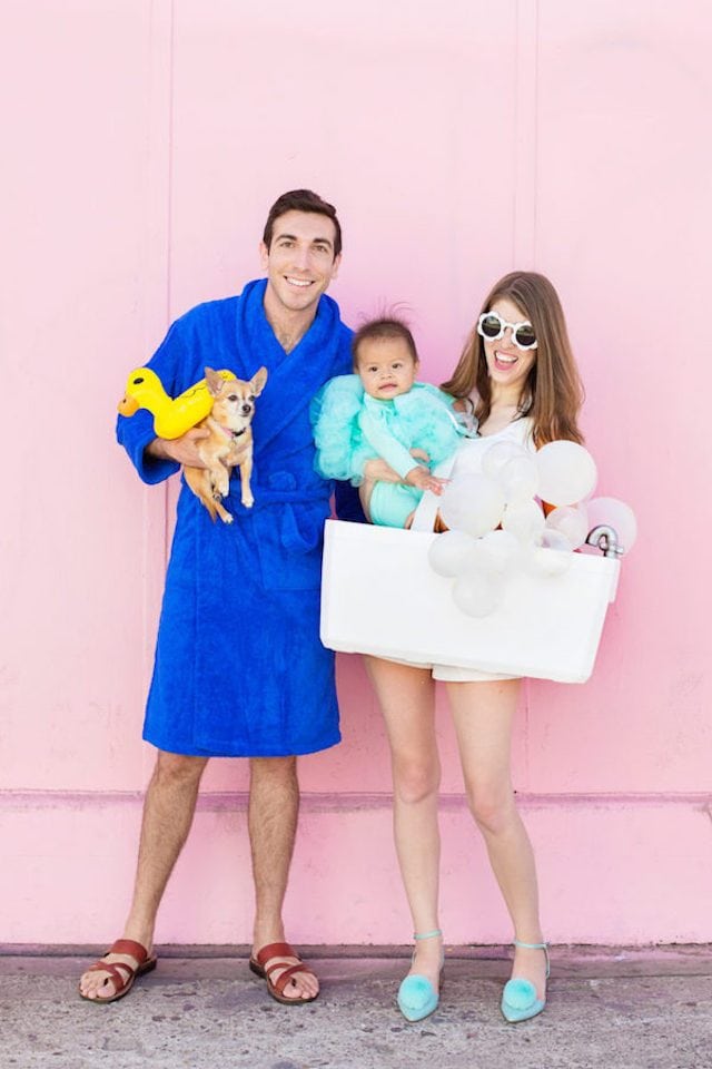 Photo of parents, baby, and dog in DIY bath time Halloween costumes: Bubble bath, loofa, man in robe, rubber ducky