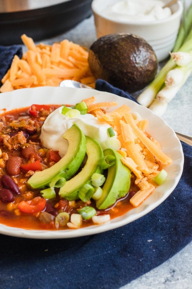 photo of the Best Easy Turkey Chili Recipe garnished with avocado, cheese and sour cream by top Houston lifestyle blogger Ashley Rose of Sugar & Cloth