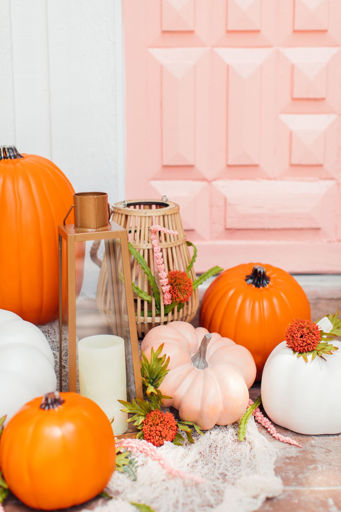 photo of pumpkins in front of a pink door