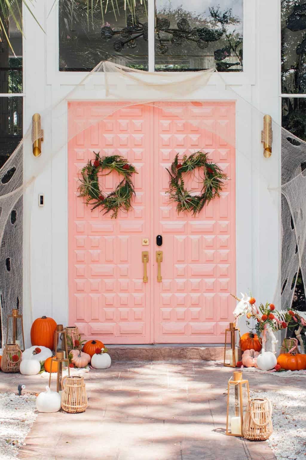 photo of a pink front door with halloween door decor