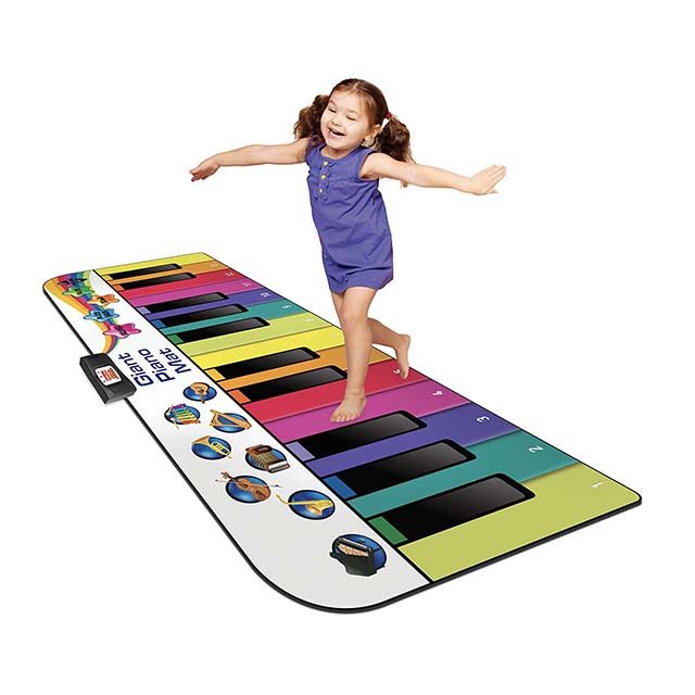photo of a little girl jumping on a large floor keyboard
