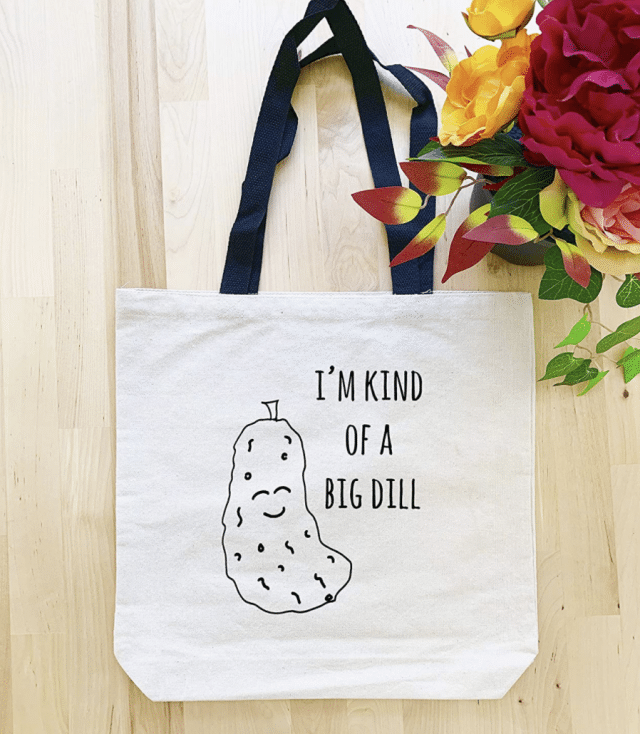 photo of tote bag that says 'kind of a big dill' over a dill pickle white elephant gift bag