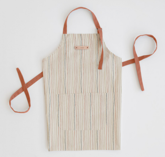 a striped apron laying flat with a personal name tag