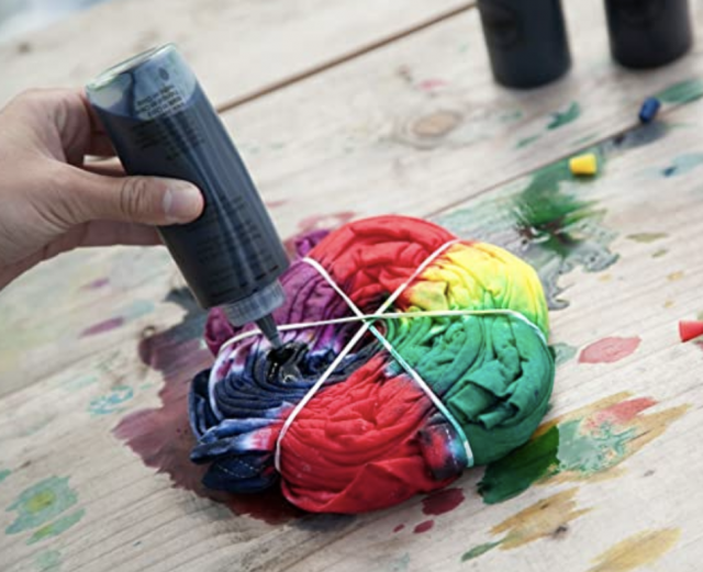 photo of tie dye kit with a girls hand using it