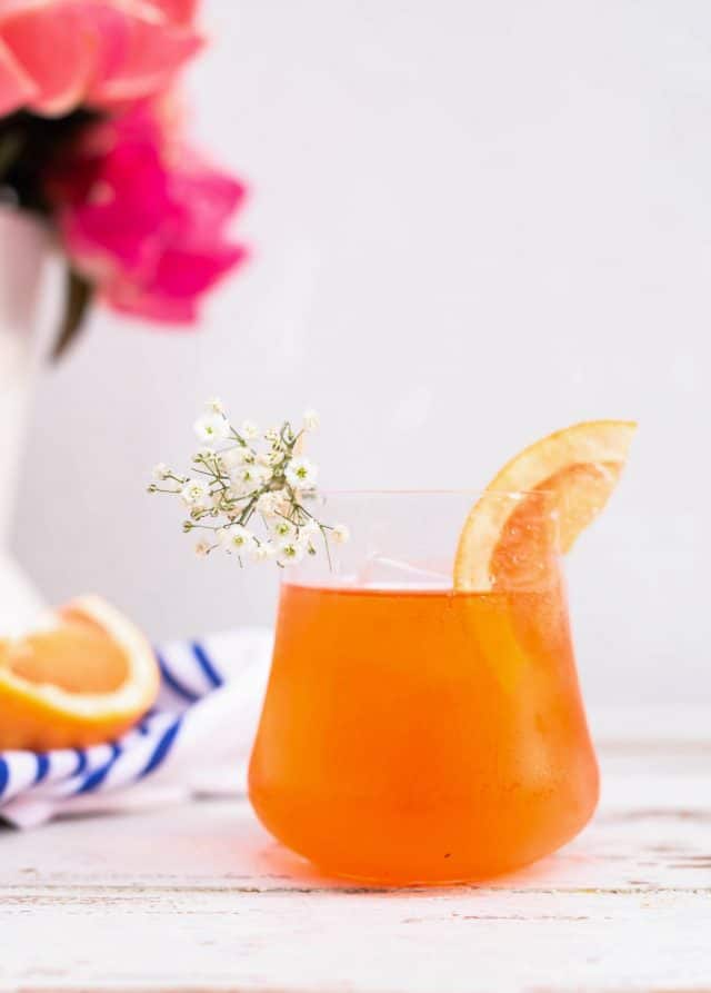 photo of a grapefruit slice and baby's breath as garnishes for an Elderflower Aperol Spritz by top Houston lifestyle blogger Ashley Rose of Sugar & Cloth