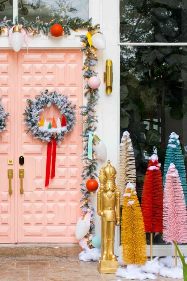 photo of a front entrance decorated for christmas with a pink door