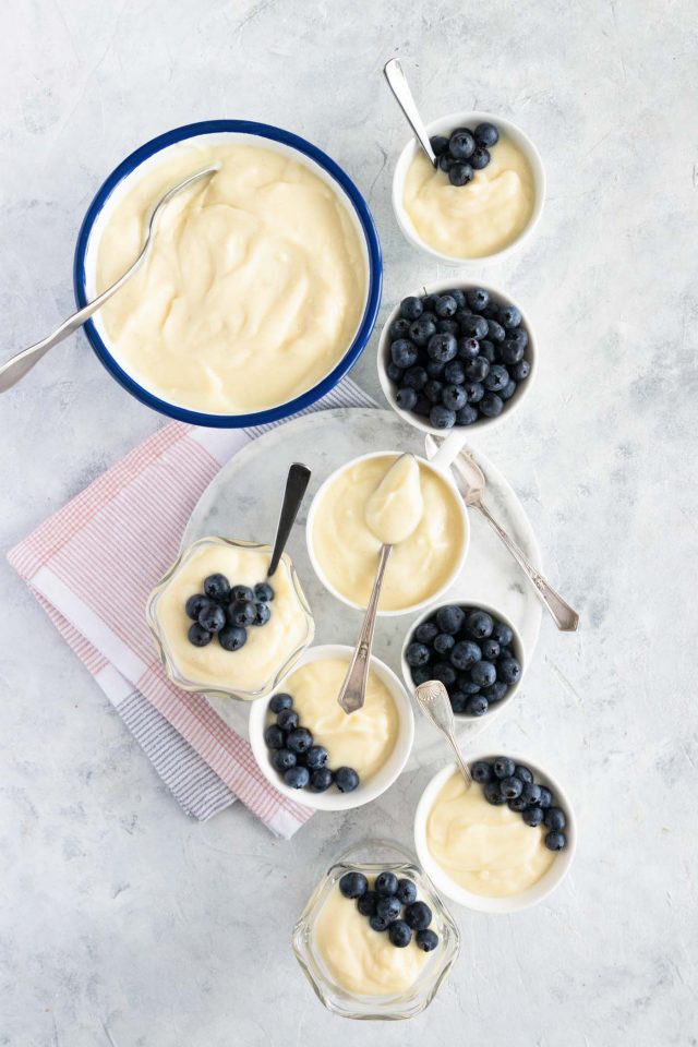 photo of several bowls full of homemade vanilla pudding with blueberries