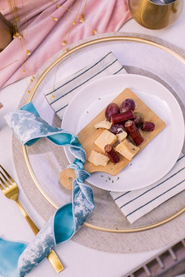 a mini personal cheeseplate at a table setting with belcampo beef sticks