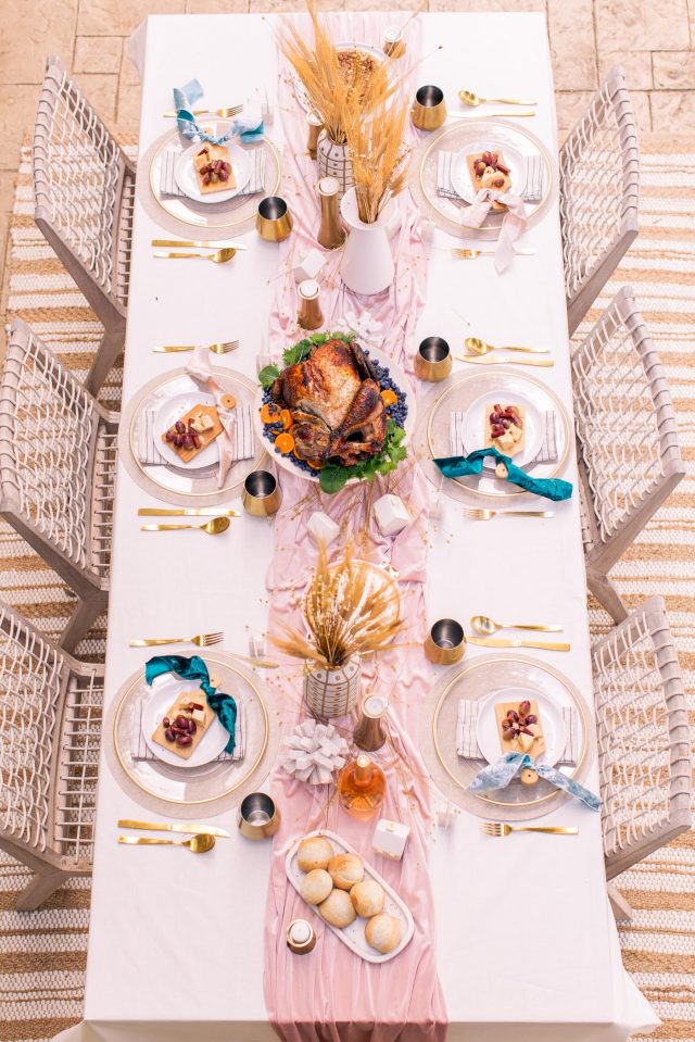 an overhead shot of a thanksgiving table with a turkey on it