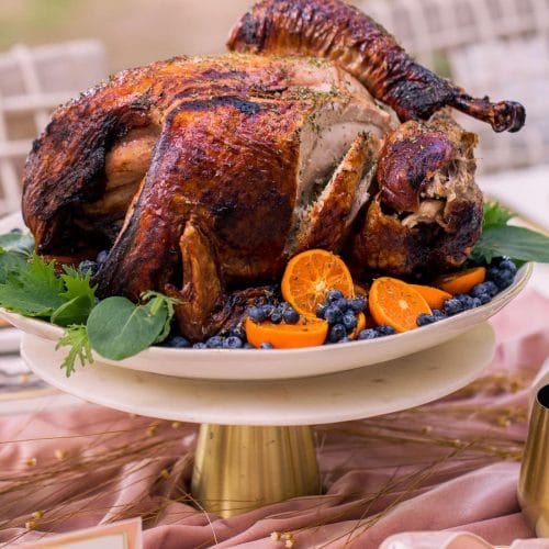 photo of a sliced thanksgiving air fryer turkey with berries and greens