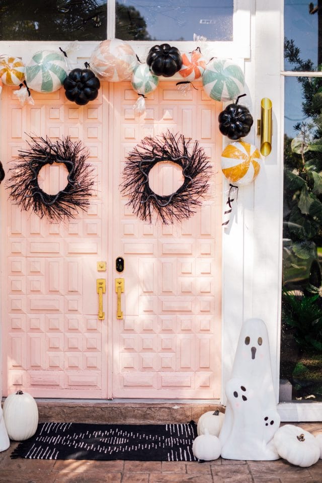 pink front door with two black wreath and ghost