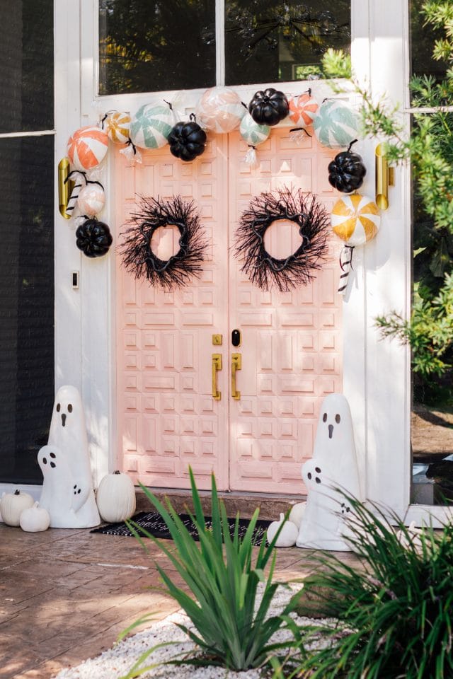 angle view of a pink front door with halloween door decor