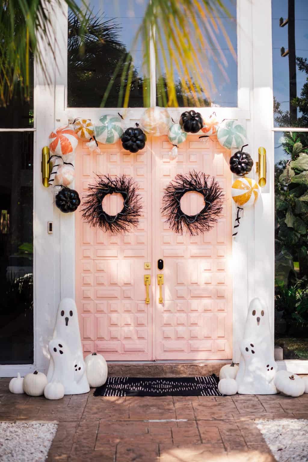 pink front door with halloween candy and ghost decorations