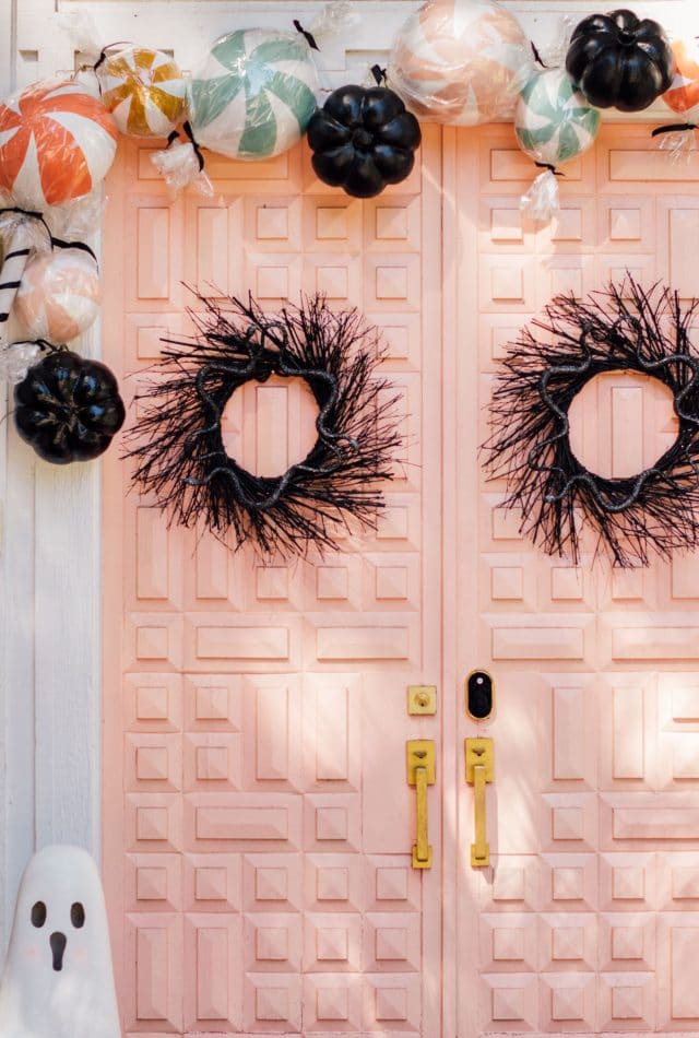 black front door wreaths on a pink door