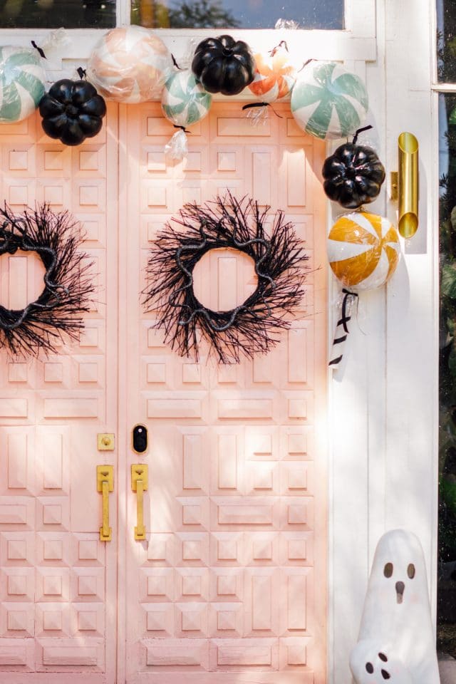 pink door with fake candy decorations and a ghost