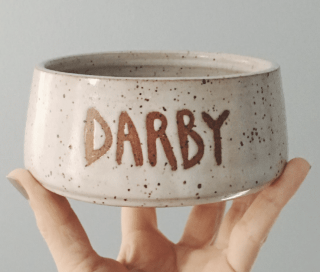 a hand holding up a custom ceramic pet bowl - best personalized gifts for her