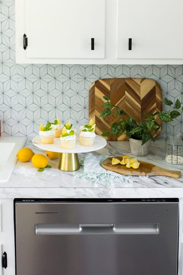 photo of the lemon cupcakes being garnished in the kitchen by top Houston lifestyle blogger Ashley Rose of Sugar & Cloth