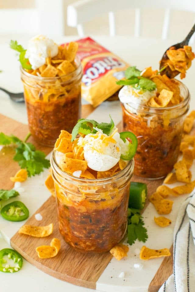 photo of the frito pie mason jars garnished with sour cream, onions and jalape&ntilde;os by top Houston lifestyle blogger Ashley Rose of Sugar & Cloth