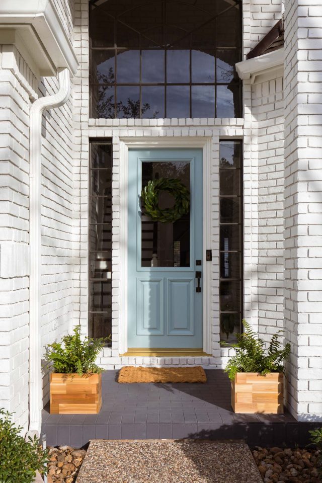 a limewash painted brick front porch and white brick exterior