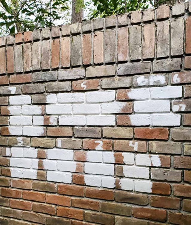 painted white color samples on a brick wall