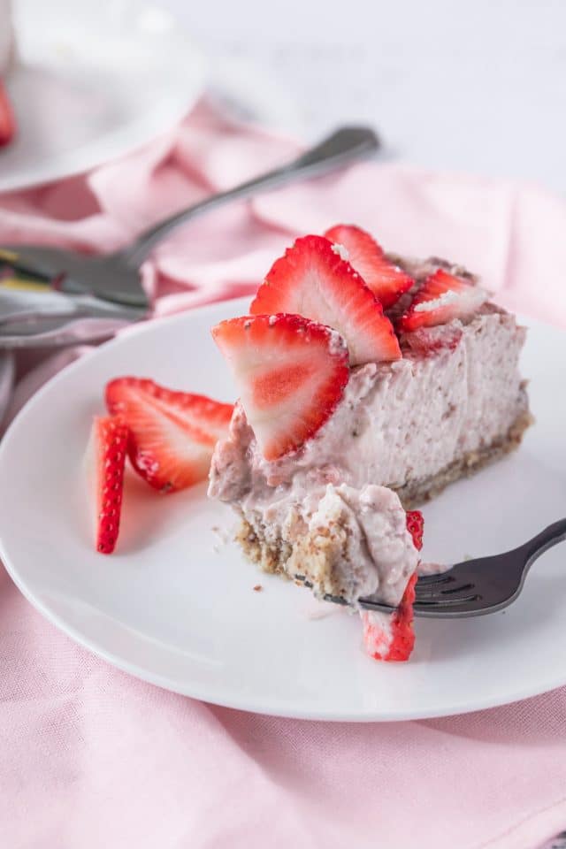 close up photo of a slice of keto strawberry cheesecake by top Houston lifestyle blogger Ashley Rose of Sugar & Cloth