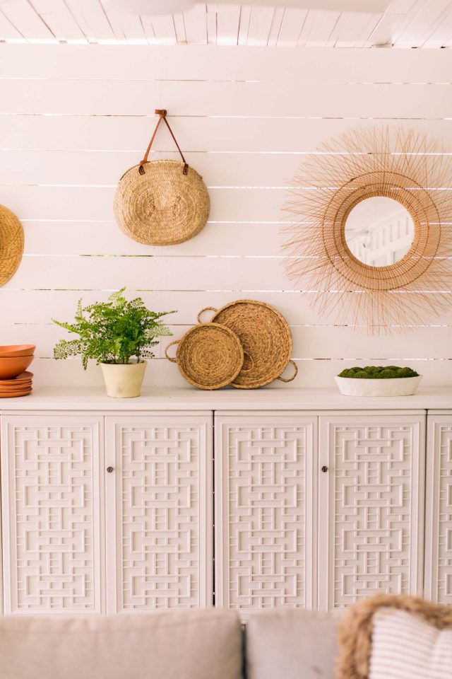 mirrors and rattan weavings on shiplap wall