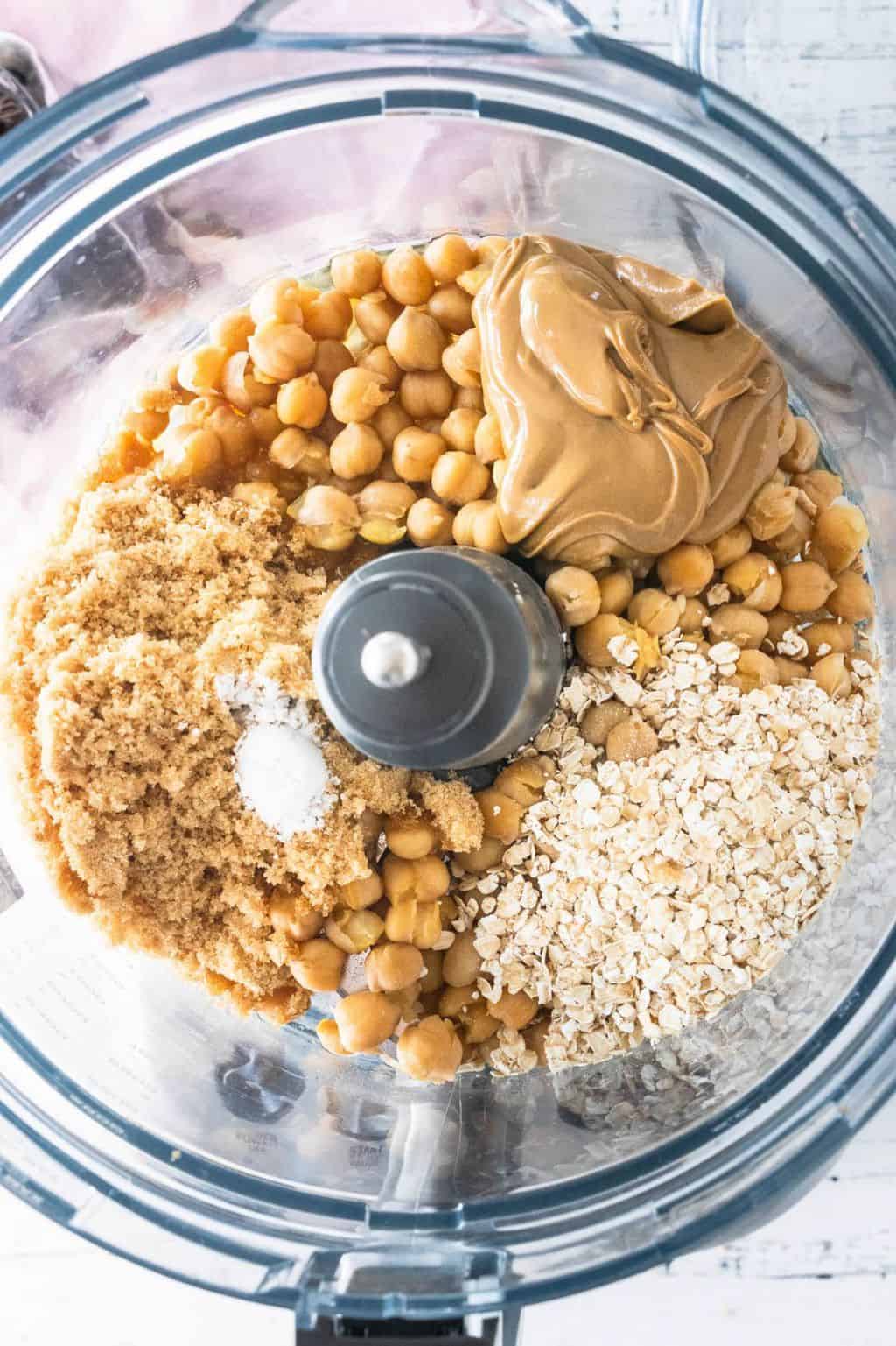 Chickpeas, nut butter, sweetener, salt, baking powder, and oats, and vanilla extract in the bowl of a food processor for the Chickpea Cookie Dough