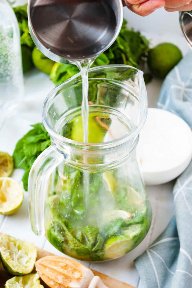 easy mojito recipe pitcher - pouring freshly lime juice inside a pitcher.