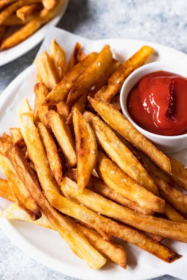 french fries - a plateful of french fries with salt and a ketchup sauce