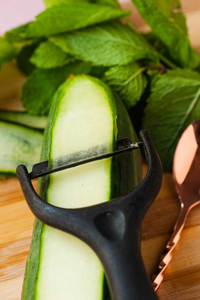 martini extra dry - a potato peeler peeling a cucumber to make cucumber ribbons as a garnish 