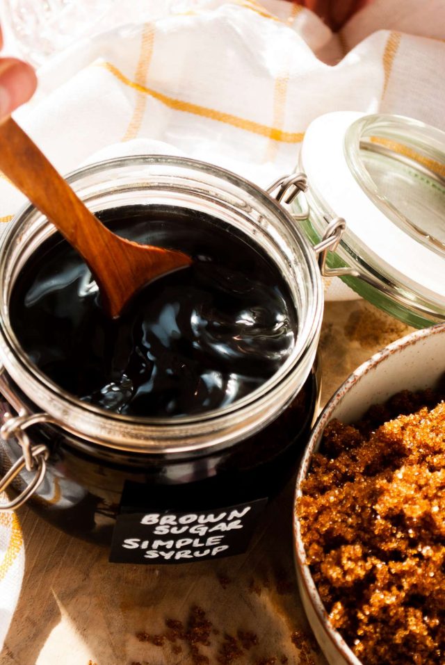 sugar syrup - black liquid with wooden spoon in the jar