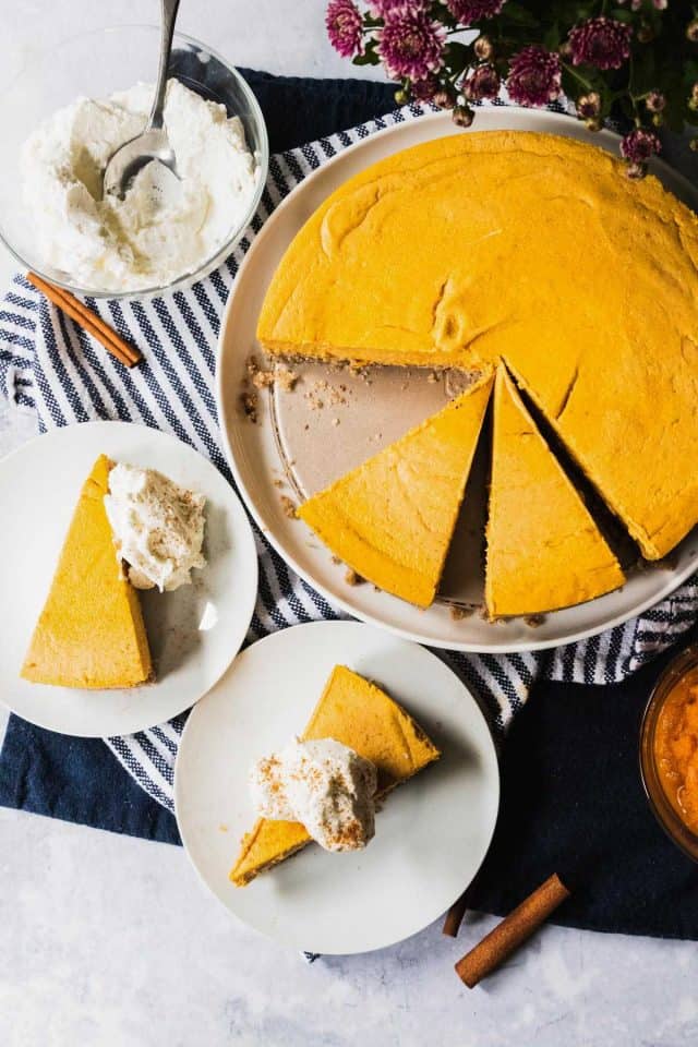 keto pumpkin pie cheesecake - slice of a cheese cake with and without a whipping cream