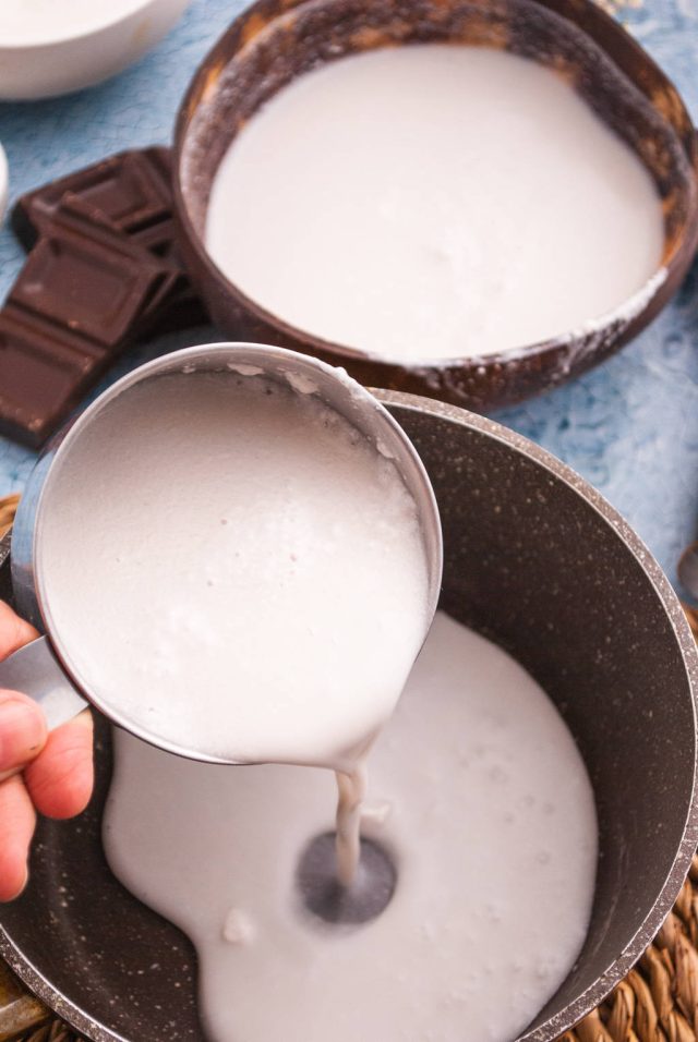 adding the coconut milk, the granulated white sugar, and a pinch of salt to create cream of coconut