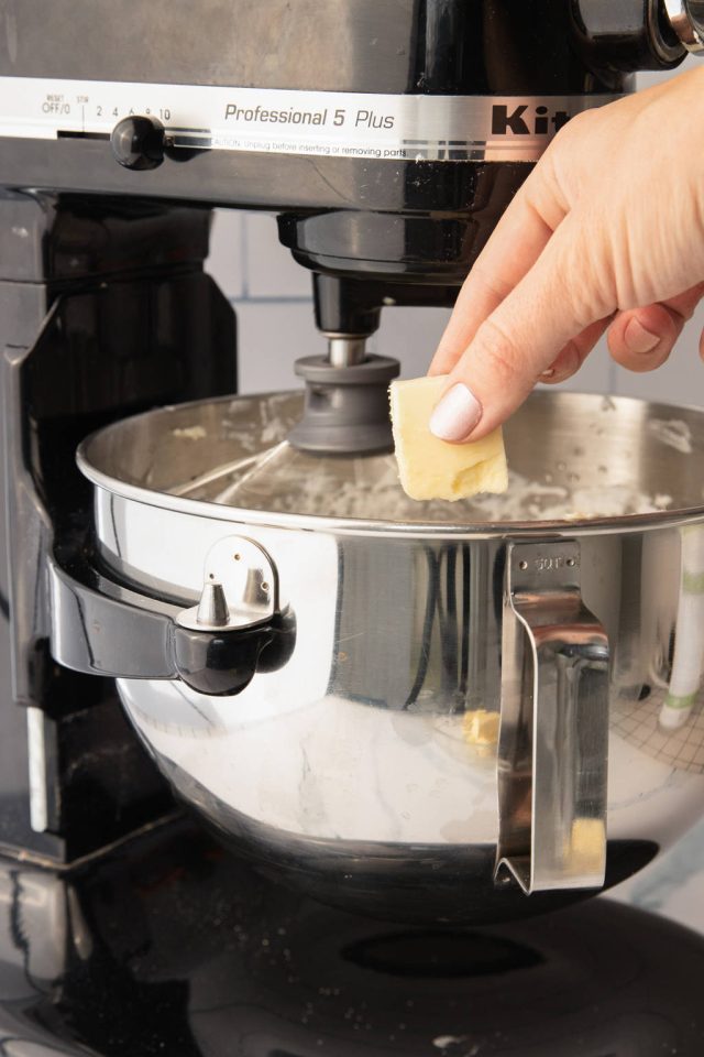adding the vanilla extract and the butter one piece at a time in the mixer | italian meringue frosting