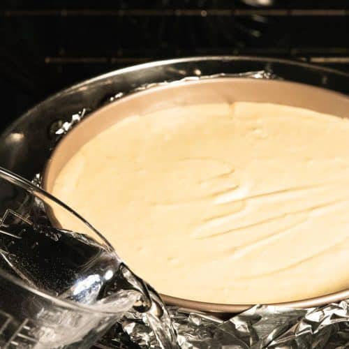 Pouring the hot water in the pan around the cheesecake