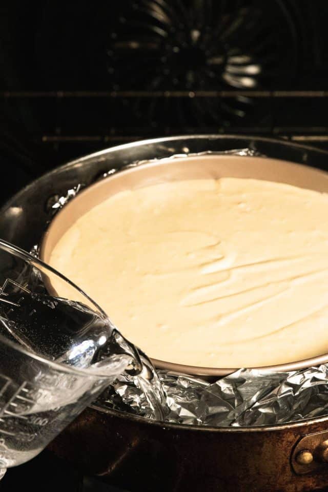 Pouring the hot water in the pan around the cheesecake